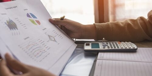Businessman or accountant or banker making calculations and re check financial reports are set of documents prepared by an administrative team at the end of an accounting period. Concept finance